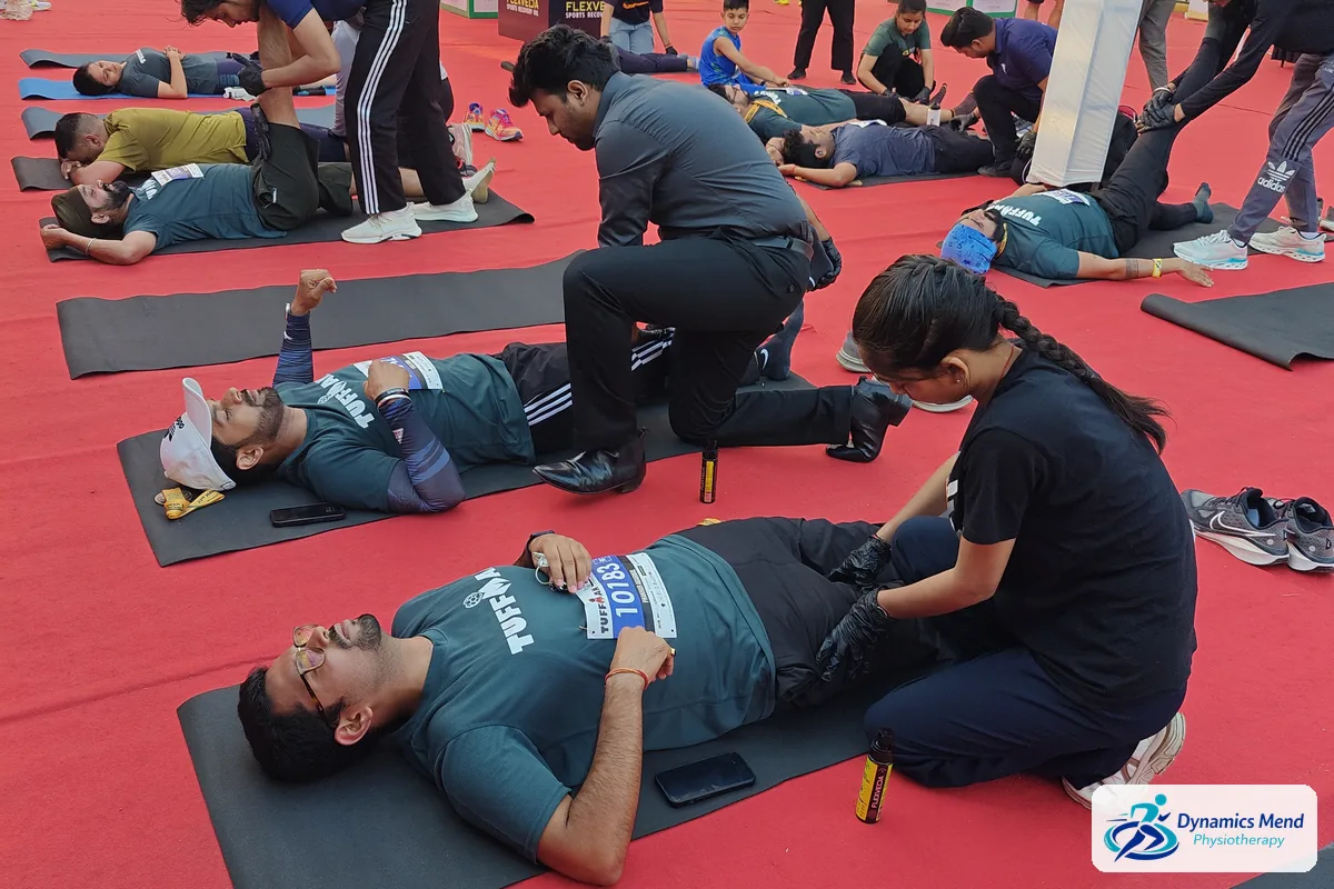 Dynamics Mend physiotherapists treating several runners at once in the post-race recovery zone