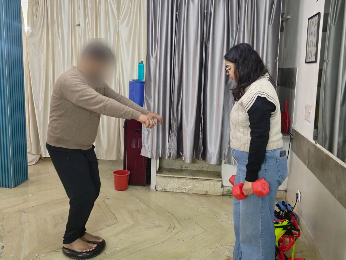 Neuro balance training session with a physiotherapist guiding a patient on a balance board at Dynamics Mend Noida