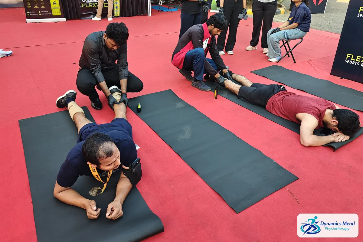 Physiotherapists working on the quads and calves of runners lying face-down after the half marathon