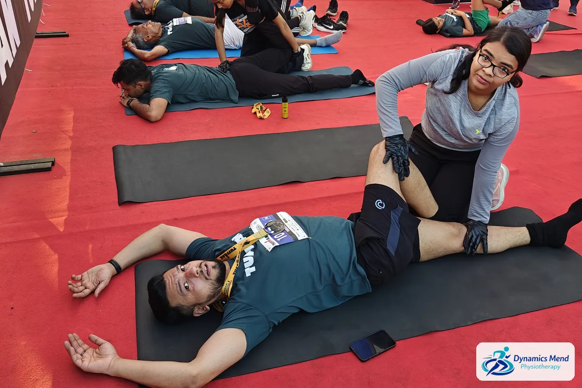 Physiotherapist stretching a runner's hip and thigh after the half marathon