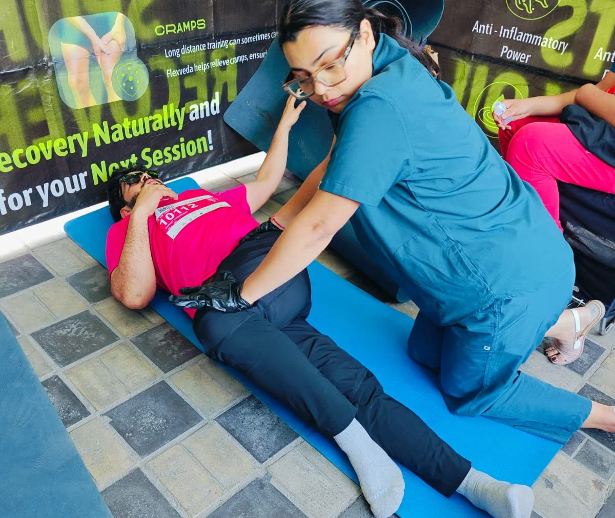 Dr. Purti Shukla giving post-race recovery physiotherapy to a runner at a Noida walkathon
